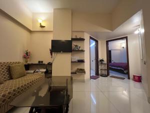 Una sala de estar con un sofá y un televisor. en Comfortia Guest House 2 Bed DringDining, en Karachi