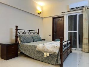 un dormitorio con una cama y una ventana en Comfortia Guest House 2 Bed DringDining, en Karachi