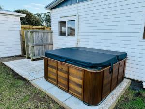 a hot tub sitting next to a house at Private Spa Retreat, Pet-Friendly Whitianga Stay in Whitianga