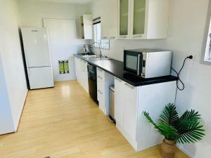 a kitchen with a counter top with a microwave at The Bach - Spa Pool, Pets, Scooters & Family Friendly in Whitianga