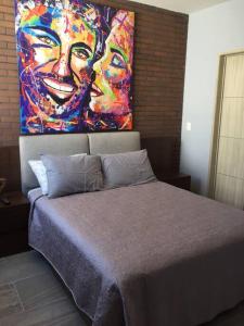 ein Schlafzimmer mit einem Bett und einem Gemälde an der Wand in der Unterkunft Departamento amueblado de lujo in La Concepción + 25 Fotos