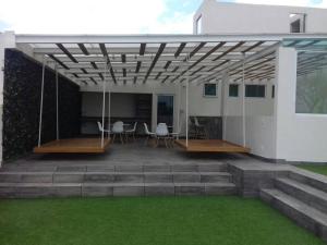 eine Terrasse mit Stühlen und einem Tisch auf einem Haus in der Unterkunft Departamento amueblado de lujo in La Concepción