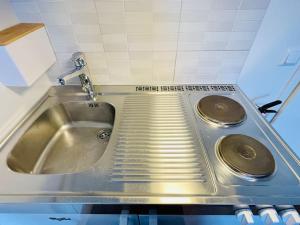 Un fregadero de acero inoxidable en una cocina con encimera en Studio apartamento em Tromsø Noruega, en Tromsø 45 fotos más