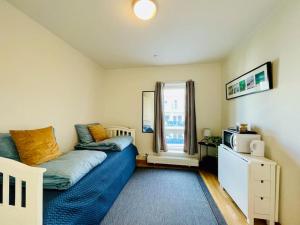 1 dormitorio con 1 cama y microondas. en Studio apartamento em Tromsø Noruega, en Tromsø