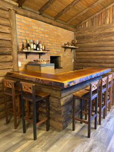 a large wooden bar in a wooden cabin with stools at Refúgio Rota das Nuvens in Bom Jardim da Serra +16 photos