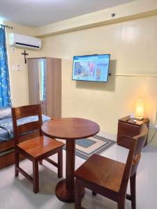 a living room with a table and chairs and a tv at Zhabret's Place II in Lapu Lapu City +3 photos