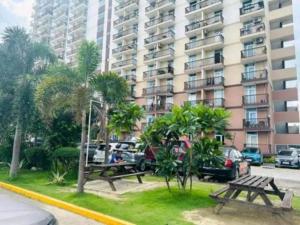 two picnic tables in front of a large apartment building at Zhabret's Place II in Lapu Lapu City