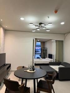 Una sala de estar con una cama, una mesa y sillas. en HS Homestay Shore Pasar Besar dan KK Plaza, en Kota Kinabalu