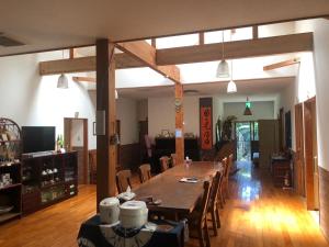 a dining room with a large wooden table and chairs at ティダ民宿結の家 in Sekirubu
