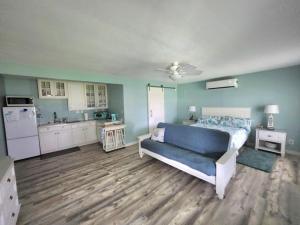 a bedroom with a blue bed and a kitchen at Coastal Cottage Bay House in Palacios