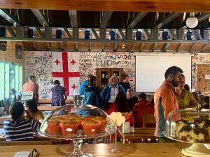 a group of people standing in a room with food at Zeta Camping -Chaukhi View Mountain Retreat in Jut'a