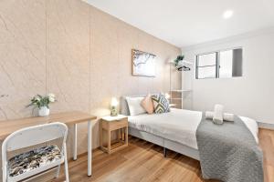 a small bedroom with a bed and a table at Boutique Queen Room - Centrally Located at Glenfield - Shared Bathroom in Glenfield