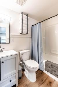 ein weißes Badezimmer mit Toilette und Dusche in der Unterkunft thsldo 1 - Downtown Lincoln Apartment in Lincoln + 13 Fotos