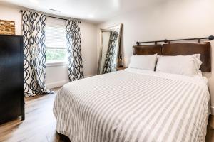 ein Schlafzimmer mit einem Bett mit gestreifter Decke und einem Fenster in der Unterkunft thsldo 1 - Downtown Lincoln Apartment in Lincoln