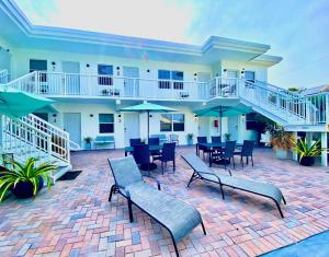 a patio with tables and chairs and umbrellas at Southwinds Inn by The Gold Nests in Hollywood