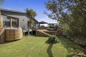 a backyard with a deck and a house at Braeside Hot Tub Retreat - 400m to Bridgewater Bay in Blairgowrie