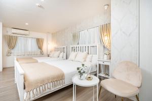 大阪市にあるビジュースイーツ グランピアの白いベッドと椅子のある白い寝室