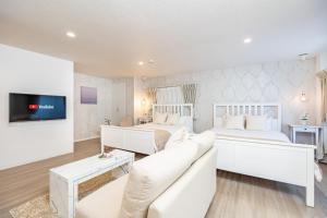 大阪市にあるビジュースイーツ グランピアの白いベッドルーム(ベッド2台、ソファ付)