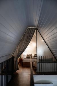 a attic bedroom with a bed and a window at Loft House - On Heifer Station Vineyard in Borenore