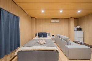 a small room with a bed and a chair at RELAX Condo Namba Daikokucho in Osaka