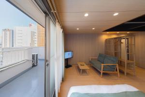 a living room with a couch and a tv on a balcony at RELAX Condo Namba Daikokucho in Osaka +22 photos