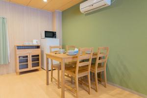 a dining room with a table and chairs and a refrigerator at RELAX Condo Namba Daikokucho in Osaka