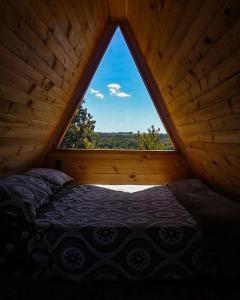 a bed in a room with a large window at Parque Repuleufu Chiloé in Ancud
