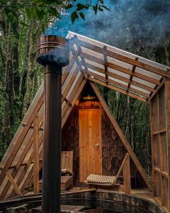 a wooden cabin with two chairs and a pole at Parque Repuleufu Chiloé in Ancud +2 photos