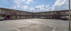 a large building with cars parked in a parking lot at DuBois Manor Motel in DuBois