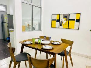 une salle à manger avec une table et des chaises en bois dans l'établissement Alyn Home Kluang V Netflix, à Keluang