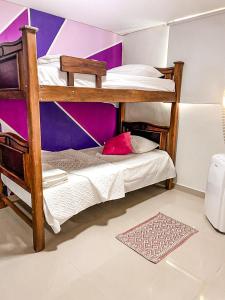 two bunk beds in a room with a purple wall at Apto cerca Estadio Metropolitano in Barranquilla