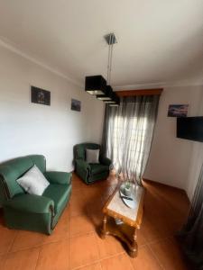 a living room with two green chairs and a table at Azores Treasure in Angra do Heroísmo