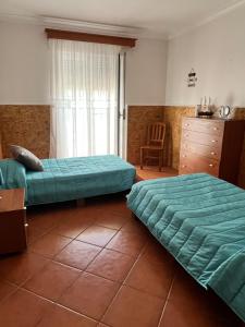 a bedroom with two beds and a dresser at Azores Treasure in Angra do Heroísmo