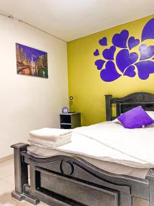 a bedroom with a bed with a painting on the wall at Apto cerca Estadio Metropolitano in Barranquilla +23 photos