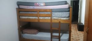 una pila de literas en una habitación en Prédio Frente Para o Mar Pé na Areia Lado Mercado Extra SEM VISTA MAR, en Praia Grande