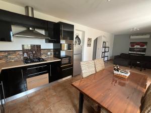 una cucina e una sala da pranzo con tavolo in legno in una stanza di A casa nostra a Biguglia