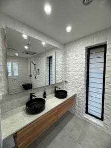 a bathroom with two sinks and a large mirror at Cockatoo Retreat in Belmont +30 photos