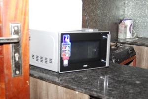 eine Mikrowelle auf einer Küchentheke in der Unterkunft The Tropics Apartment Mombasa in Mombasa + 15 Fotos