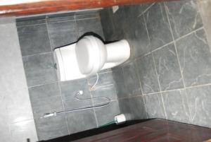 einen Toilettenpapier-Spender an einer gefliesten Wand in der Unterkunft The Tropics Apartment Mombasa in Mombasa