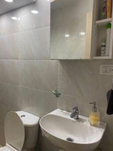 a bathroom with a white toilet and a sink at Apto cerca Estadio Metropolitano in Barranquilla