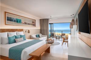 a hotel room with a bed and a living room at Dreams Estrella del Mar Mazatlan Golf & Spa Resort - All Inclusive in Mazatlán
