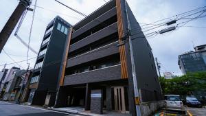 a tall black building on a city street at Apartment Hotel MODISH Gion in Giommachi