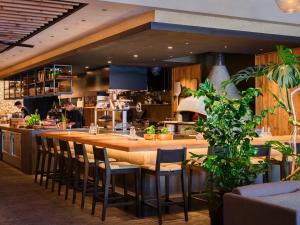 a restaurant with a large wooden bar with chairs at seven x seven ISHIGAKI in Ishigaki Island