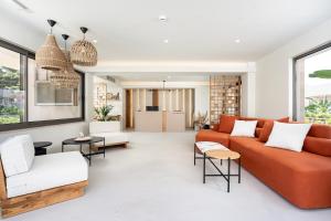 a living room with an orange couch and chairs at Sagredo Boutique Hotel & Spa in Ágios Fokás