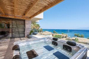 a hot tub in a house with a view of the ocean at Sagredo Boutique Hotel & Spa in Ágios Fokás