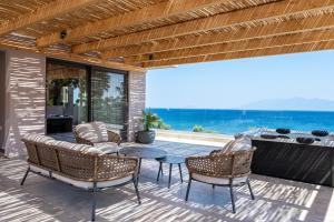 a patio with a table and chairs and the ocean at Sagredo Boutique Hotel & Spa in Ágios Fokás