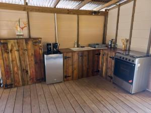 a kitchen with wooden cabinets and a stove and a refrigerator at Moe Bus House in Moorea