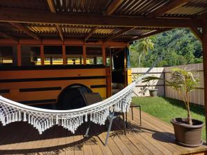 a school bus hammock on a deck with a school bus at Moe Bus House in Moorea