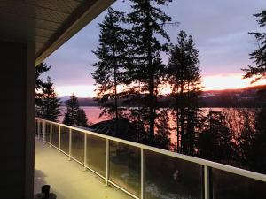 a view from the balcony of a house with a sunset at Blarney Place Retreat in Vernon