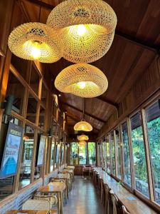 a dining room with tables and chandeliers in a building at Villa Baru 3 Bedroom in Tabanan